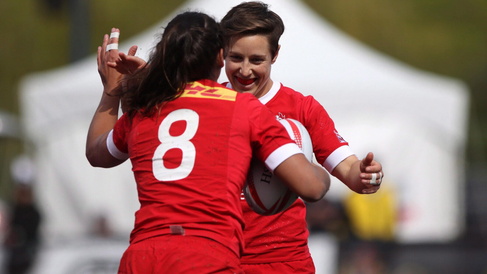 Bianca Farella et Ghislaine Landry s'enlacent après un essai de l'équipe canadienne de rugby à 7.
