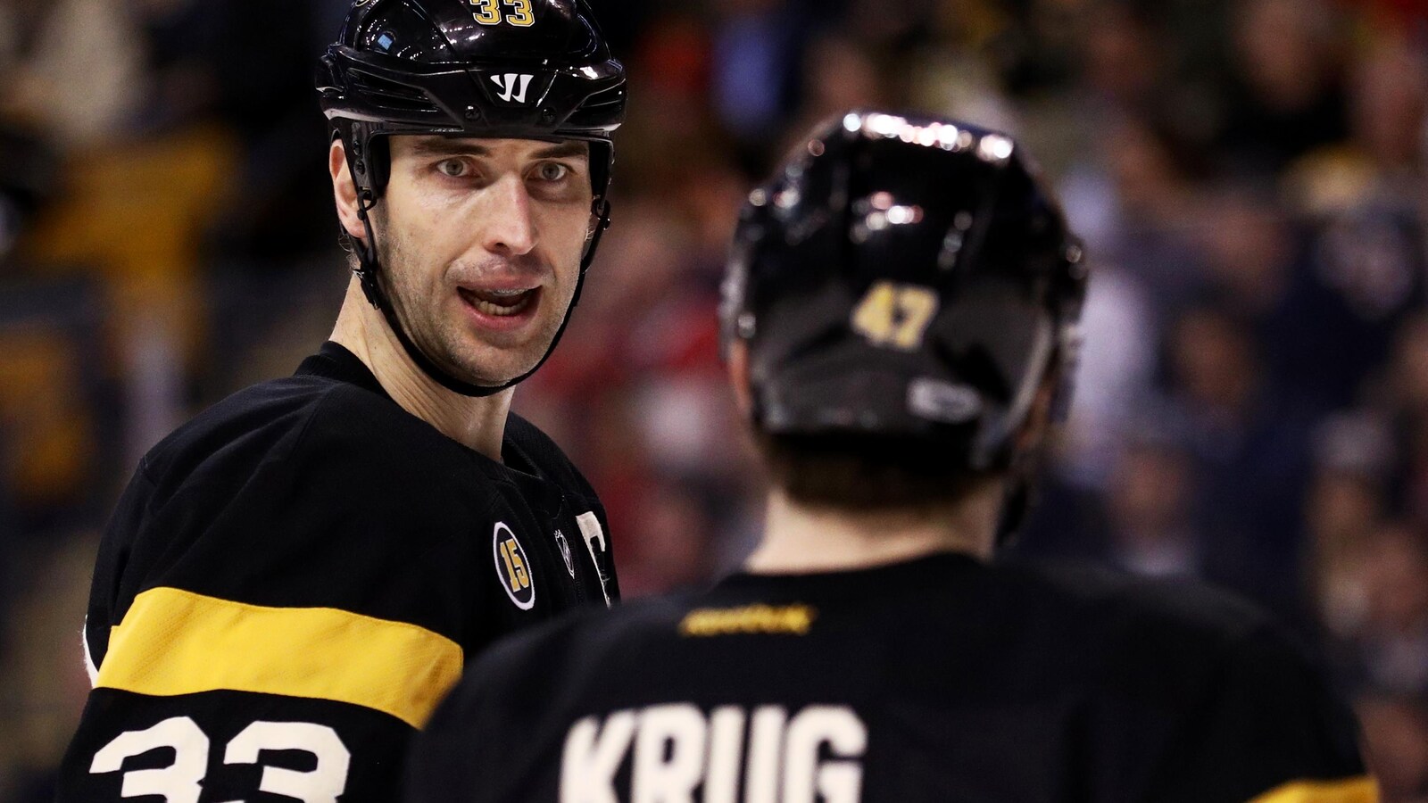 Gros plan de Zdeno Chara, de face, et de Torey Krug, de dos, les deux dans l'uniforme des Bruins de Boston