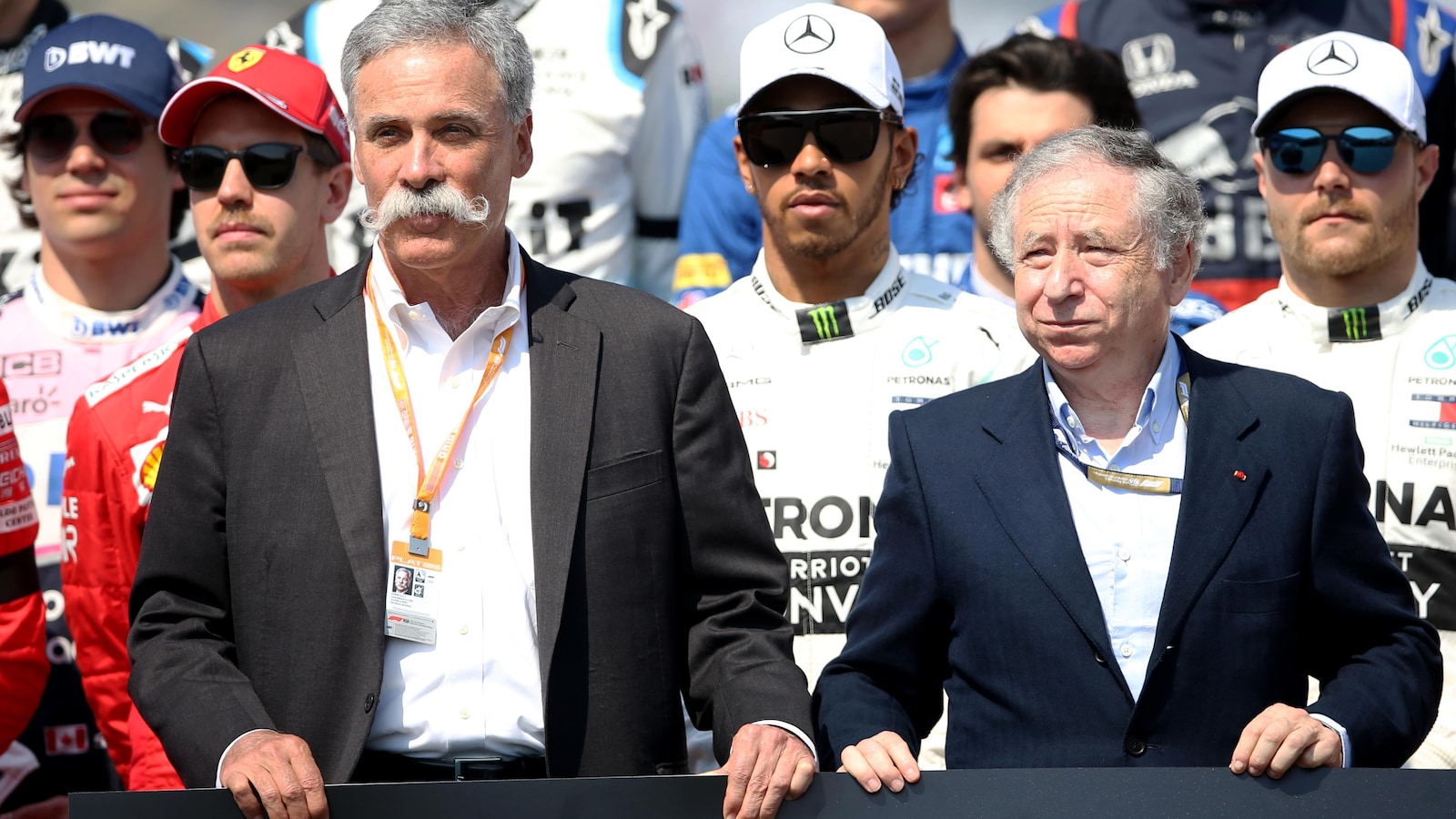 Chase Carey (à gauche) et Jean Todt sur la grille de départ du Grand Prix d'Australie, avec les pilotes dont Lance Stroll (casquette BWT) en arrière-plan