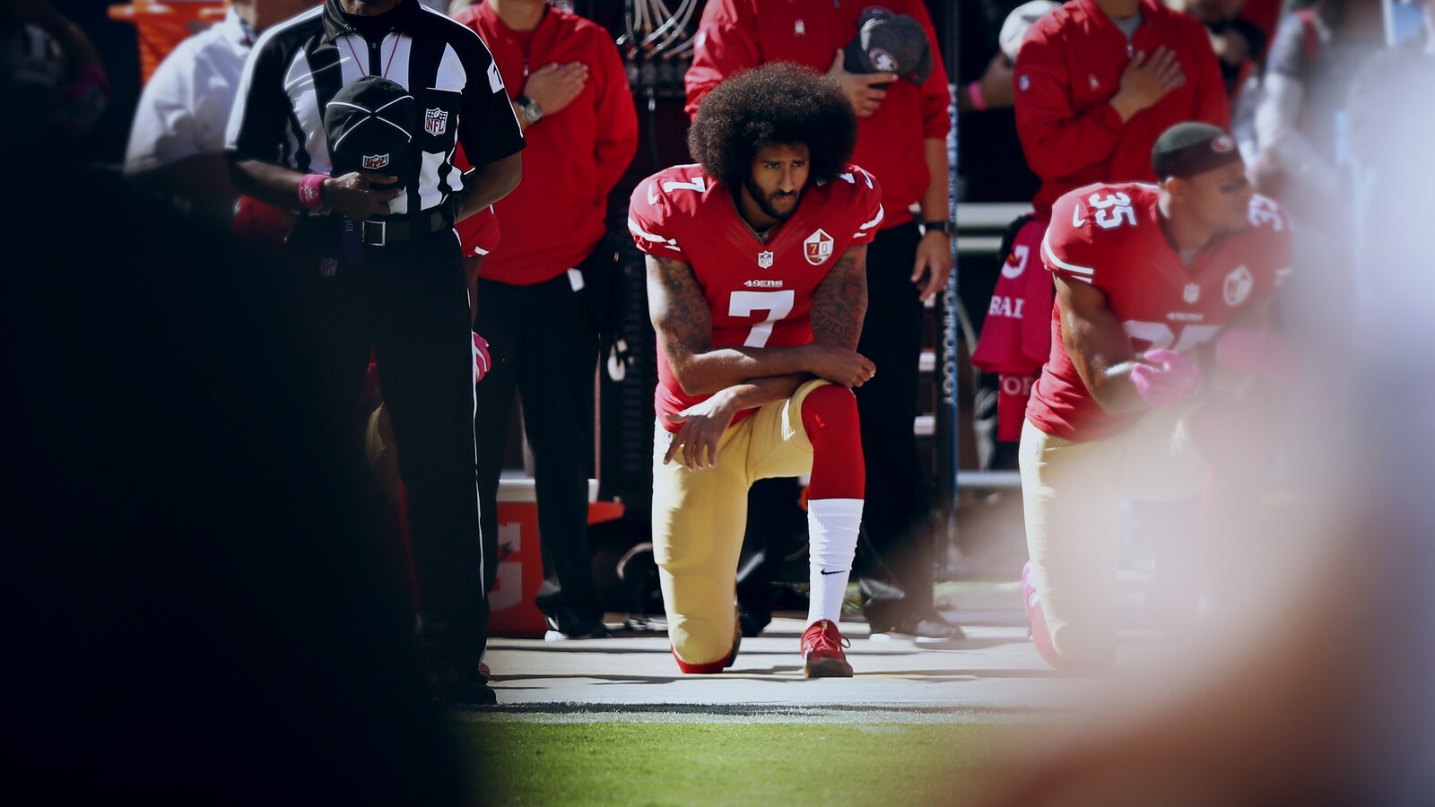 Colin Kaepernick est immobile, un genou au sol.