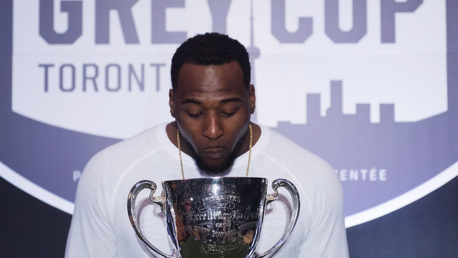 Jerome Messam des Stampeders de Calgary regarde la Coupe Grey, mais refuse de la toucher.