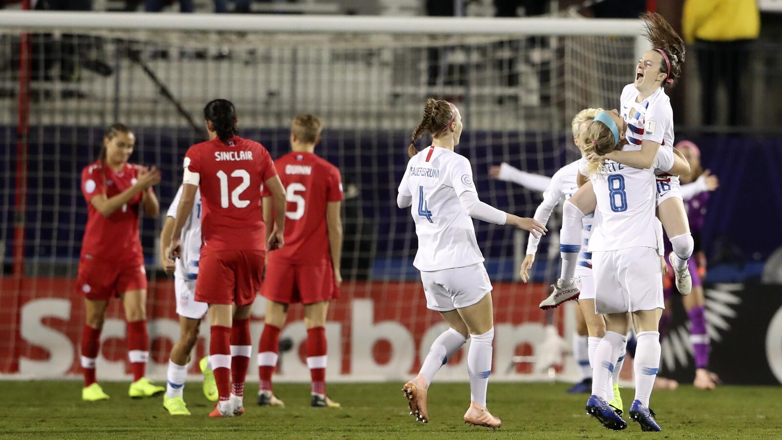 Rose Lavelle saute dans les bras de ses coéquipières américaines après avoir marqué le premier but du match contre les Canadiennes.