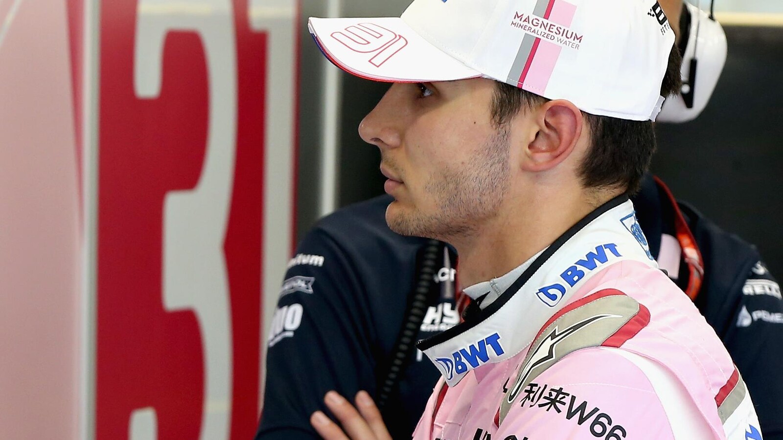 Esteban Ocon regarde un écran dans le garage de l'équipe Force India à Singapour.