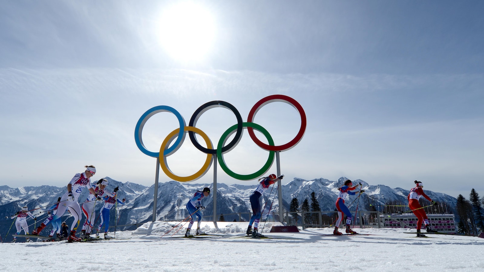 Des fondeuses skient devant les anneaux olympiques lors de l'épreuve de 30 km de cross country féminin lors les Jeux de Sotchi.