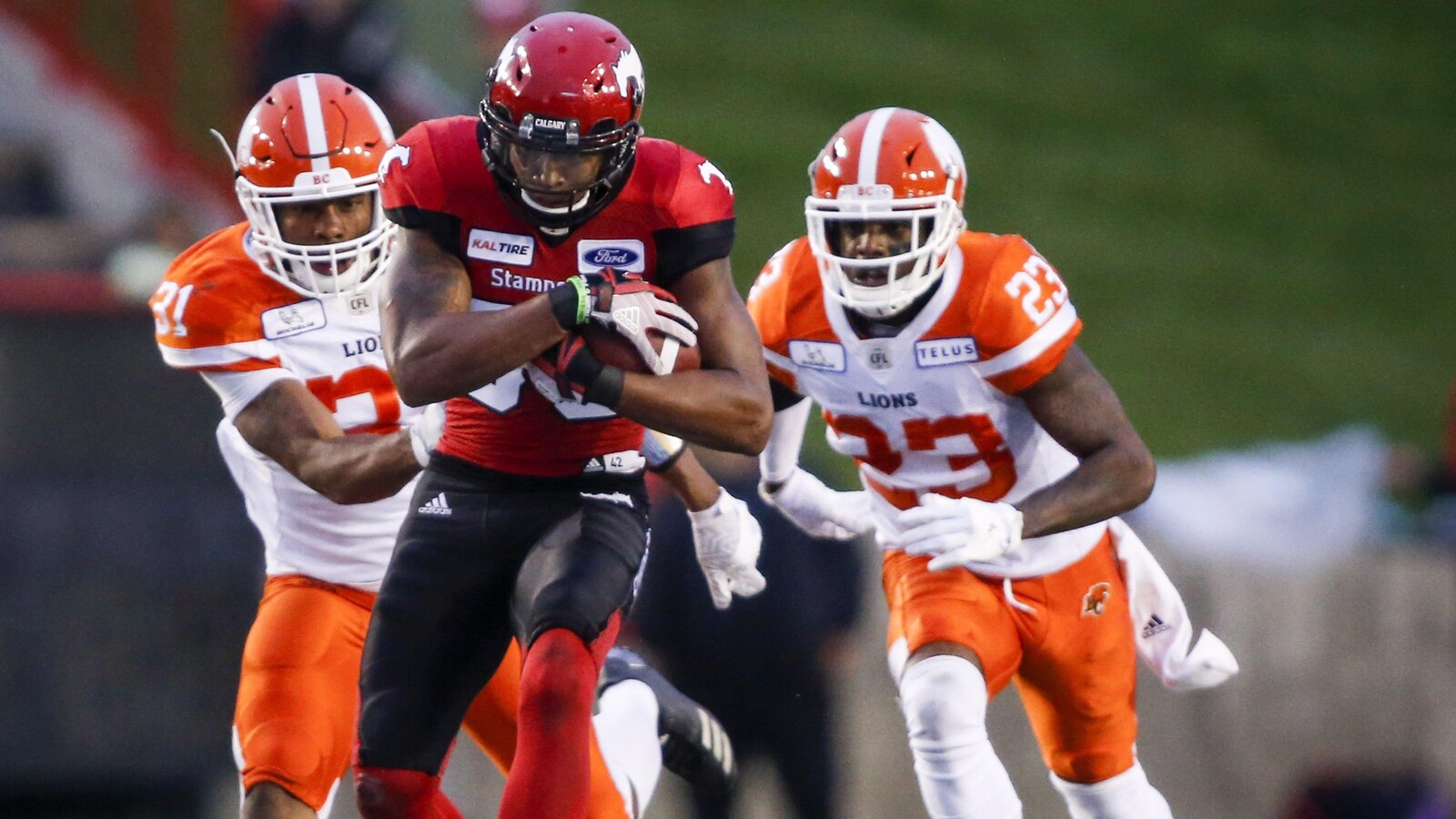 Kamar Jorden (au centre), des Stampeders de Calgary, tente de semer Otha Foster (à gauche) et Anthony Thompson, des Lions de la Colombie-Britannique.