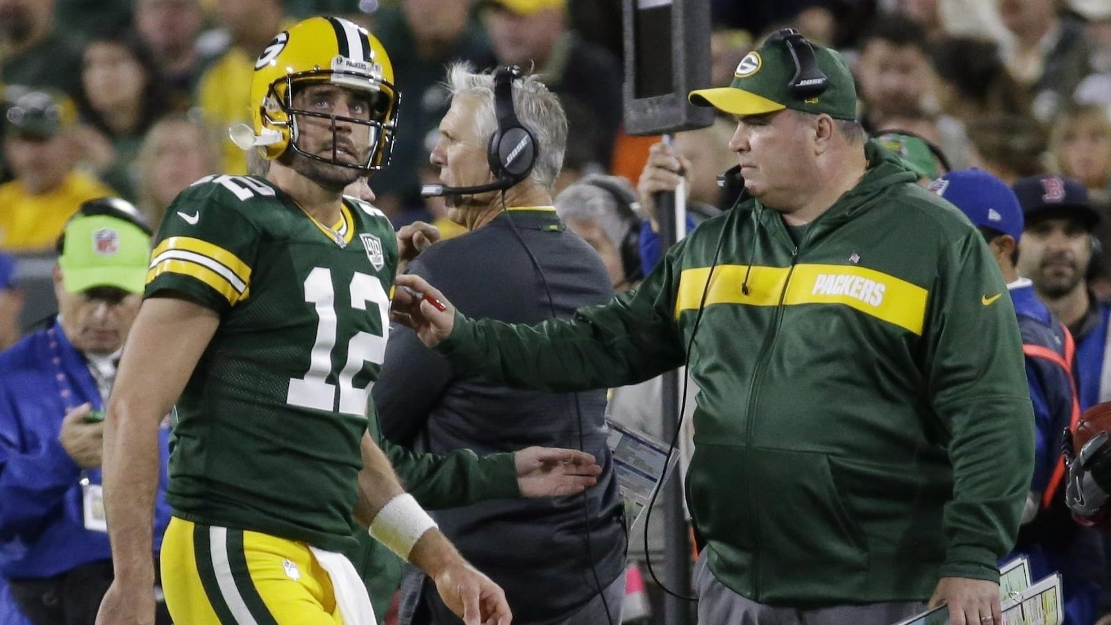 L'entraîneur-chef des Packers de Green Bay, Mike McCarthy (à droite), regarde son quart-arrière Aaron Rodgers, blessé, quitter une rencontre.