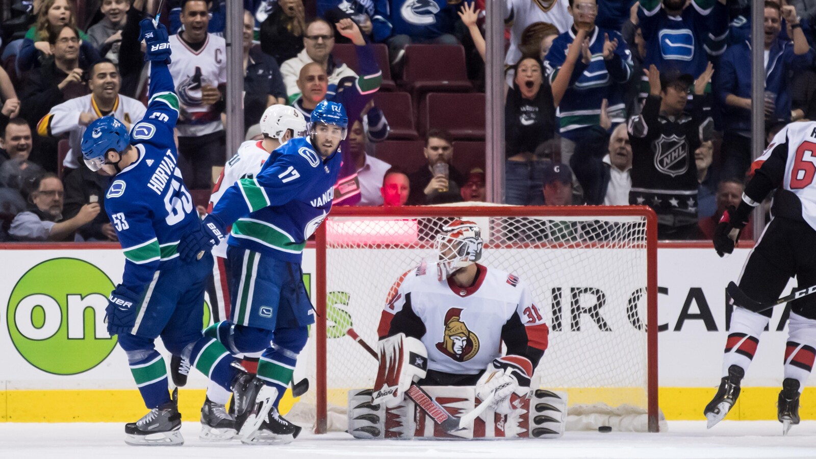 Bo Horvat (à gauche), des Canucks de Vancouver, célèbre son but contre le gardien des Sénateurs d'Ottawa, Anders Nilsson (à droite).