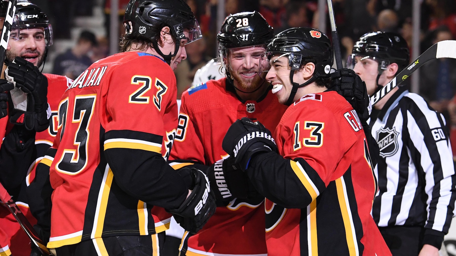 Johnny Gaudreau (à droite), des Flames de Calgary, célèbre un but marqué contre les Sharks de San José avec ses coéquipiers Sean Monahan (à gauche) et Elias Lindholm.