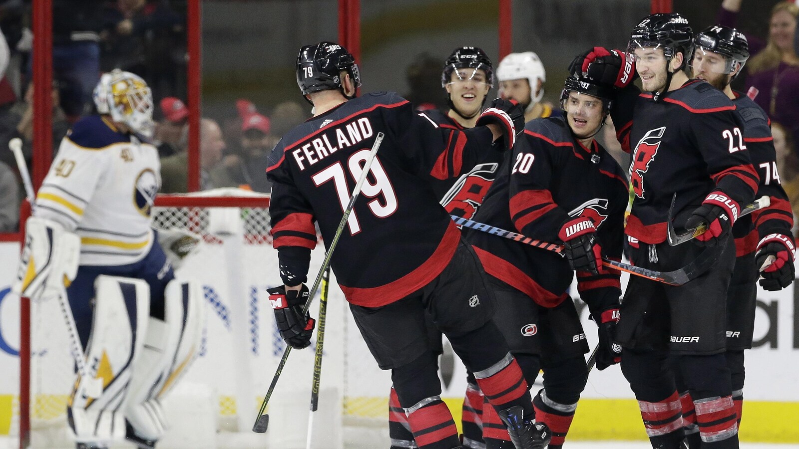 Sebastian Aho (au centre) reçoit les félicitations de ses coéquipiers des Hurricanes de la Caroline Micheal Ferland (à gauche) et Brett Pesce après un but contre les Sabres de Buffalo.