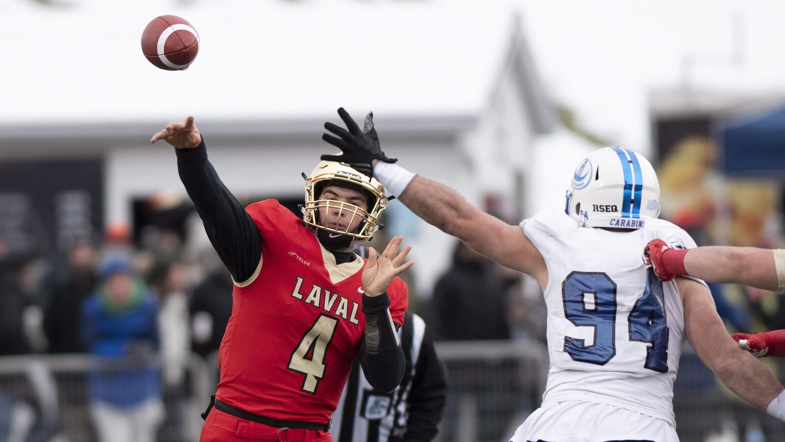 Hugo Richard évite le bloc de Philippe Lemieux-Cardinal et lance une passe dans le match de la Coupe Dunsmore à Québec.