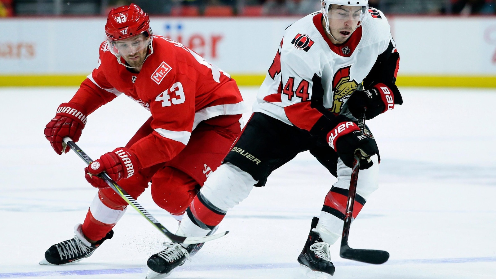 L'attaquant des Sénateurs d'Ottawa Jean-Gabriel Pageau vient de déjouer Darren Helm, des Red Wings de Détroit, durant un match.