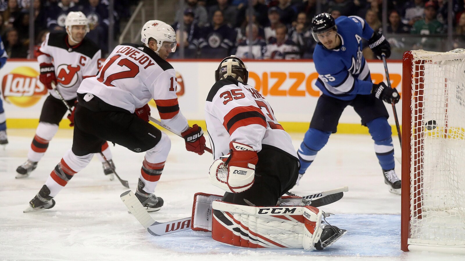L'attaquant des Jets Mark Scheifele bat d'un angle restreint le gardien des Devils Cory Schneider.