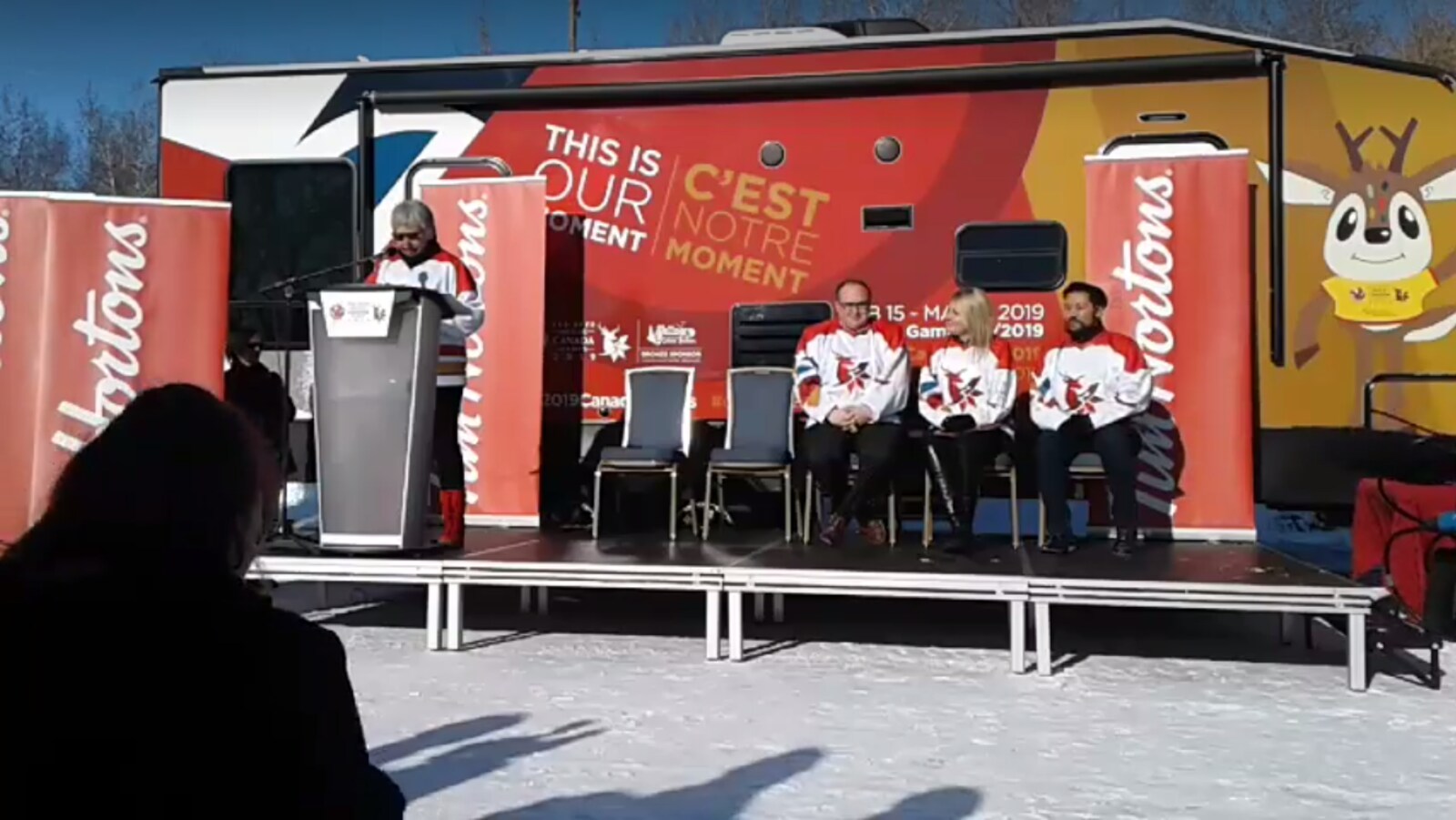 Lyn Radford, la présidente de la Société hôte des Jeux, au micro durant une conférence de presse.