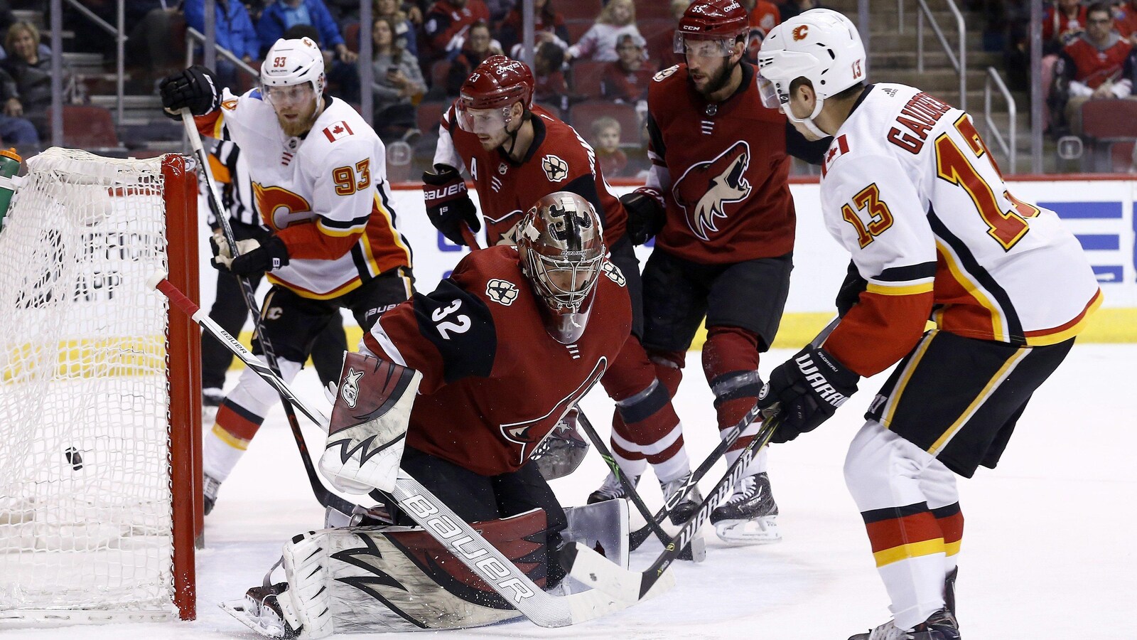 Johnny Gaudreau des Flames de Calgary pousse la rondelle derrière le gardien Antti Raanta des Coyotes de l'Arizona.