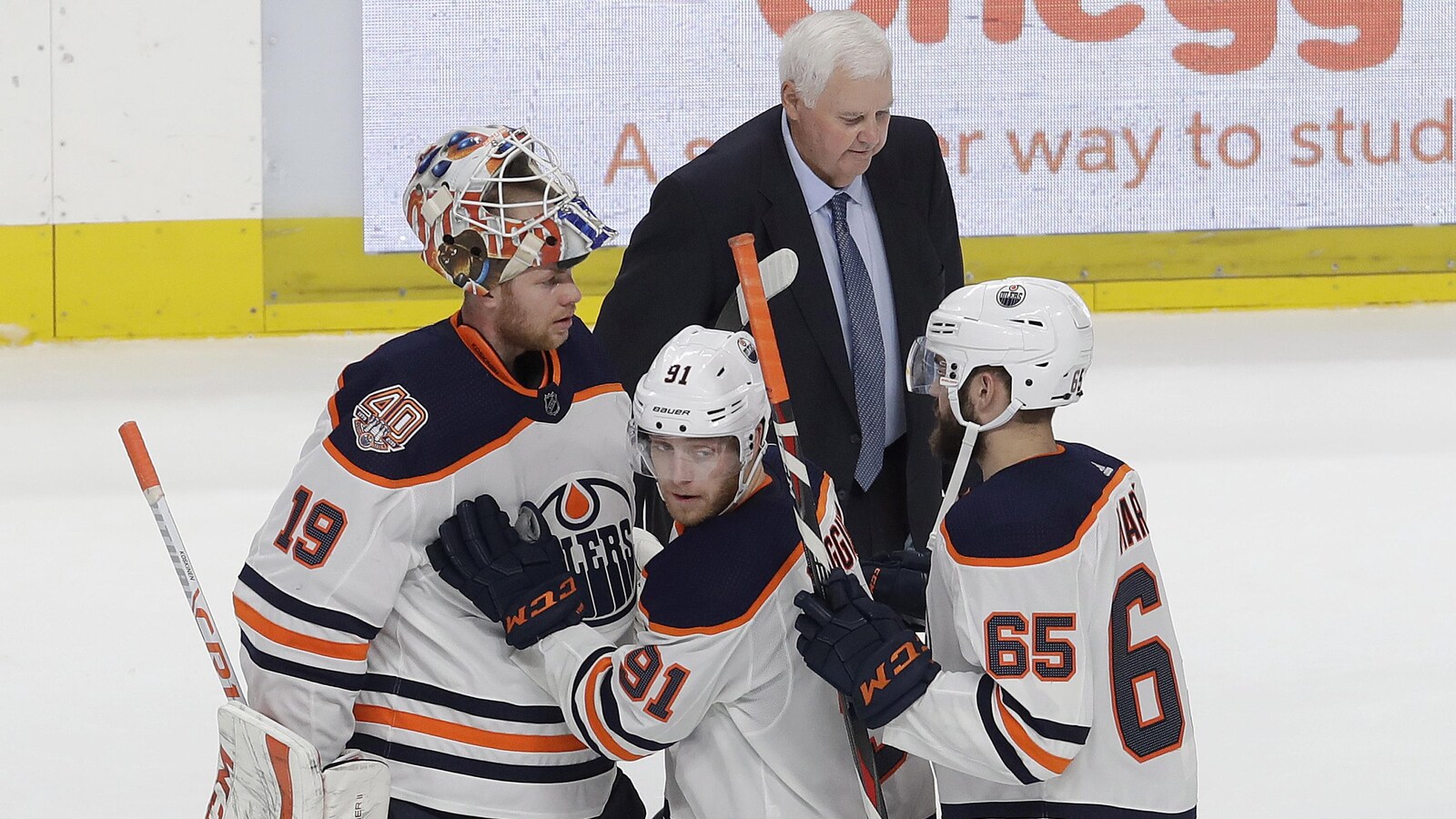 Ken Hitchcock déambule sur la glace de San José après sa première victoire avec les Oilers, alors que Drake Caggiula, Mikko Koskinen et Cooper Marody célèbrent leur succès.