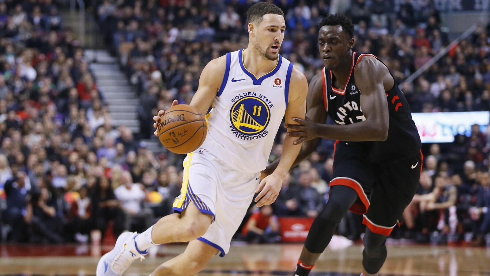 Klay Thompson des Warriors de Golden State dribble devant Pascal Siakam des Raptors à Toronto, le 13 janvier 2018.