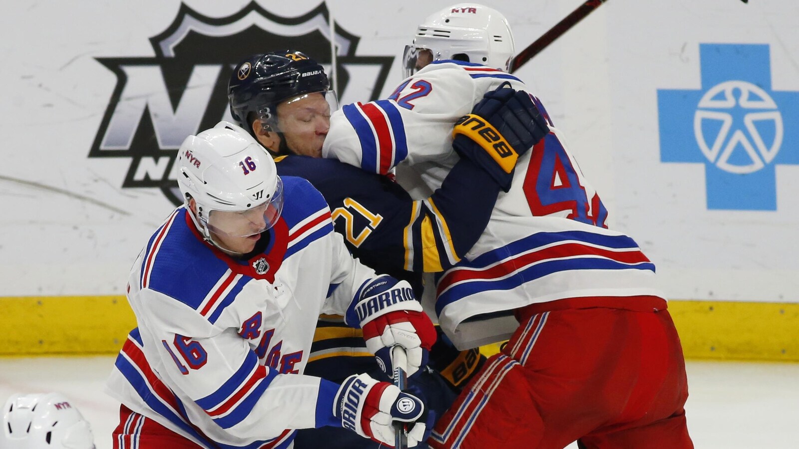 Kyle Okposo des Sabres aux prises avec Ryan Strome (16) et Brendan Smith (42) des Rangers