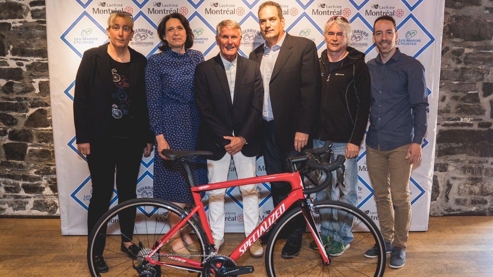 Ils posent derrière un vélo.