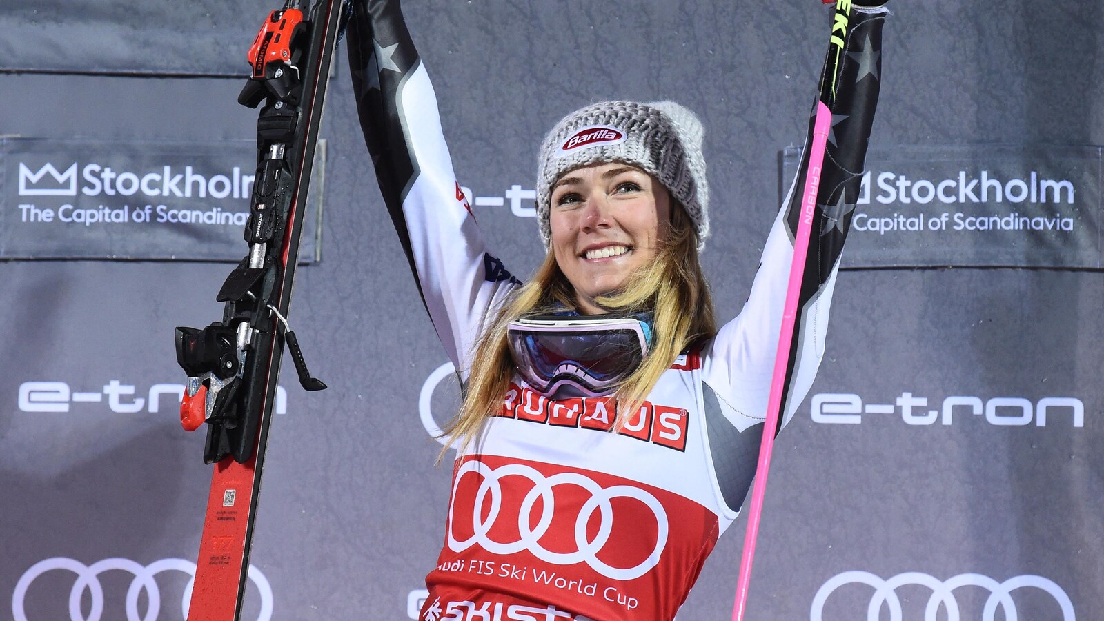 Elle tient un ski dans chaque main.
