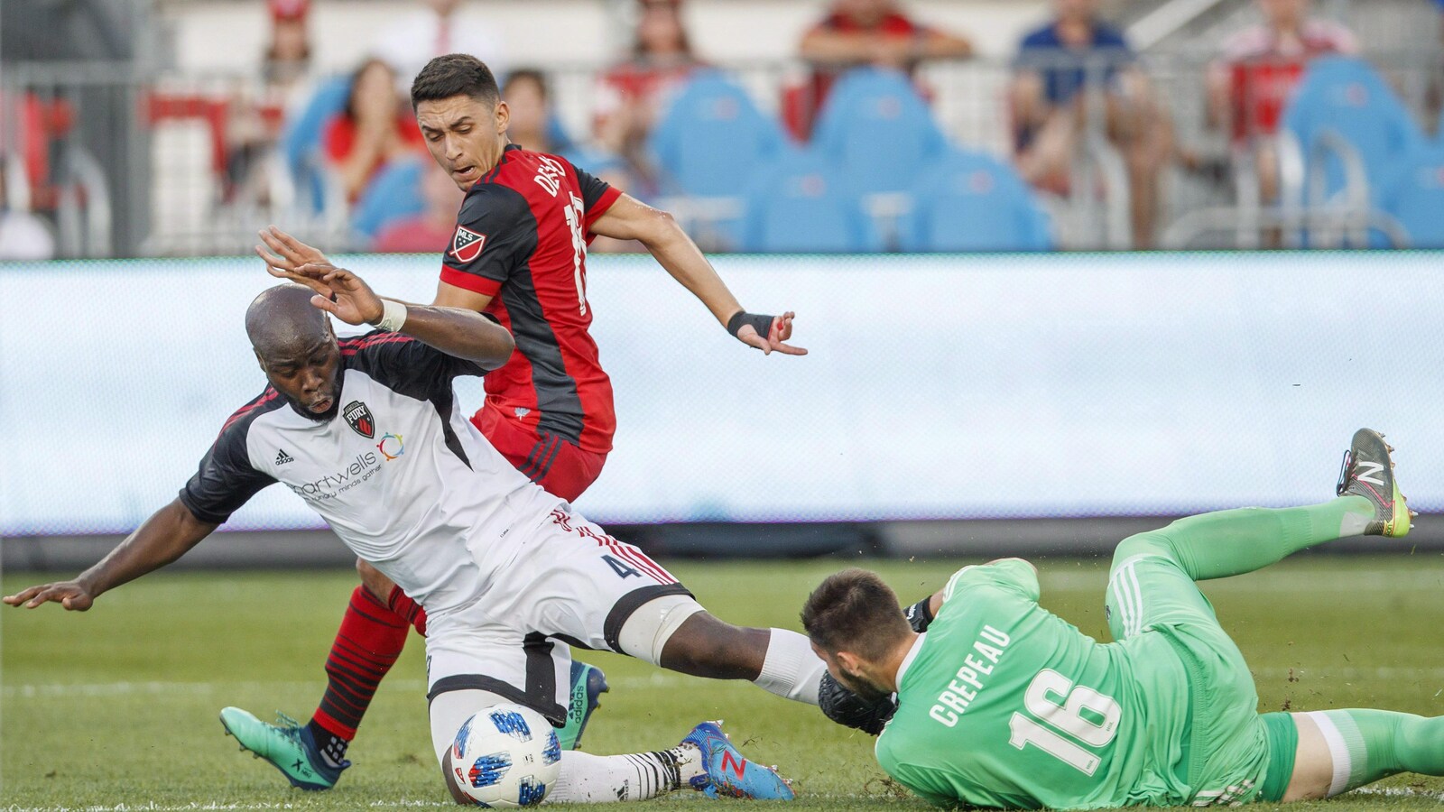 Le gardien Maxime Crépeau effectue un arrêt contre Marco Delgado du Toronto Fc pendant que son coéquipier Nana Attakora tombe sur le sol.