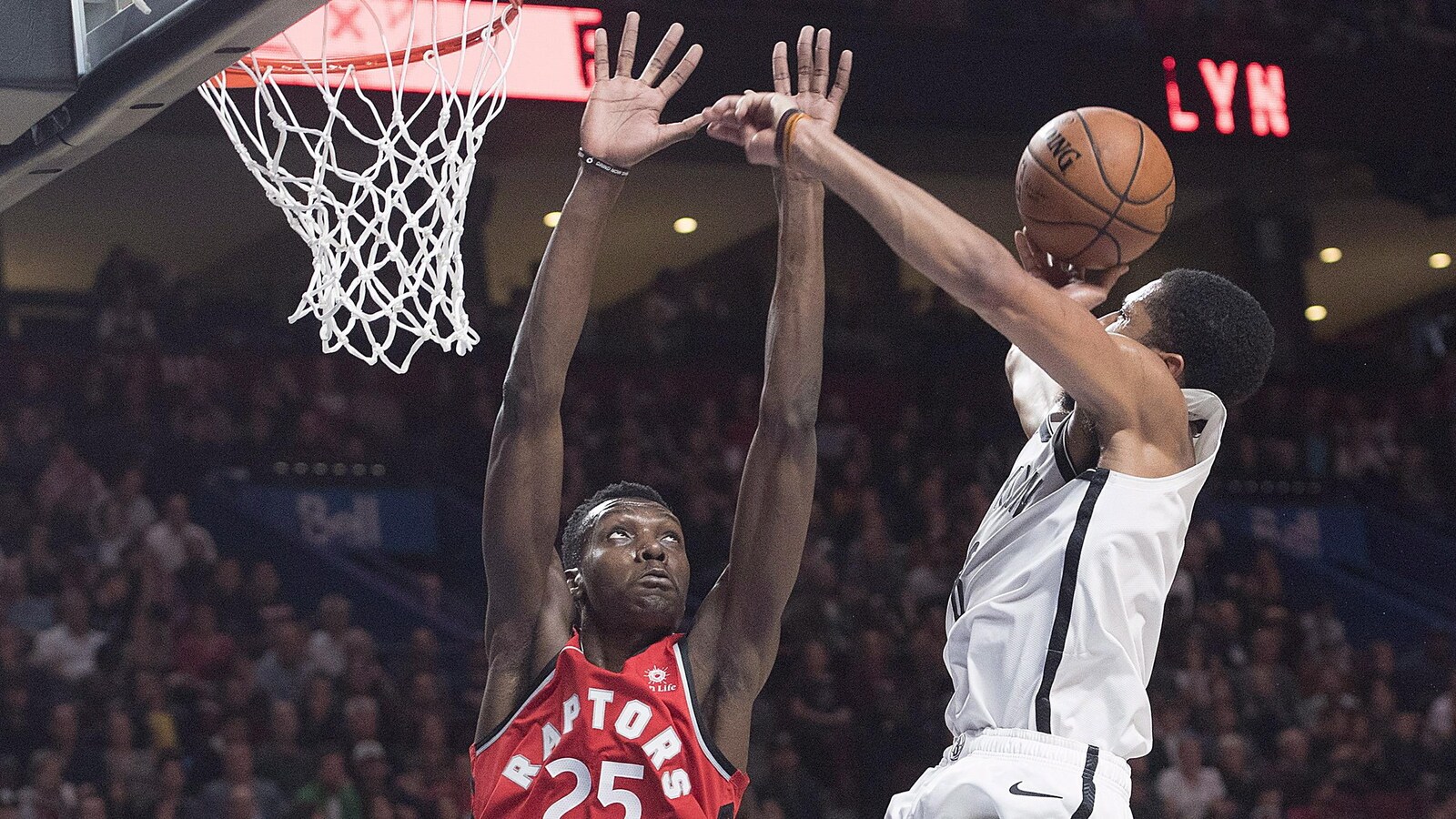 Le centre des Raptors de Toronto Chris Boucher bloque le tir du garde de Spencer Dinwiddie.