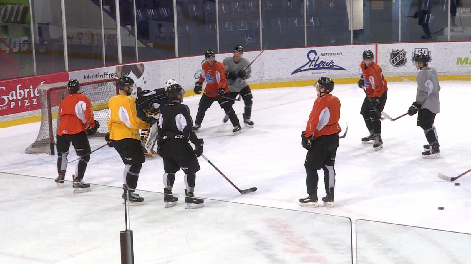 Des joueurs de hockey rigolent pendant un exercice de tirs au but