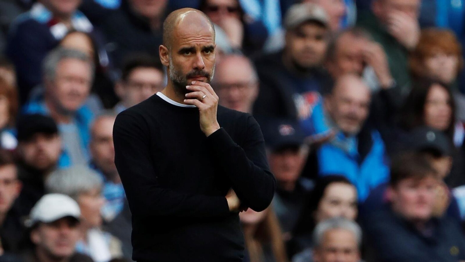L'entraîneur de Manchester City est songeur sur les lignes de côté lors d'un match.