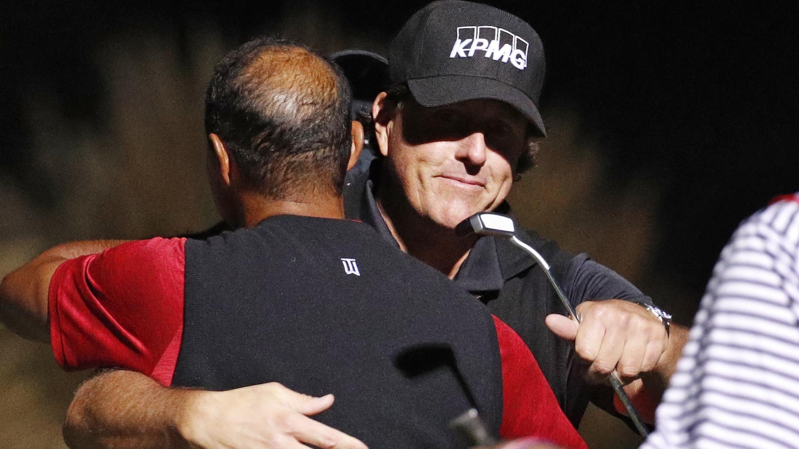 Il donne l'accolade à Tiger Woods, de dos.