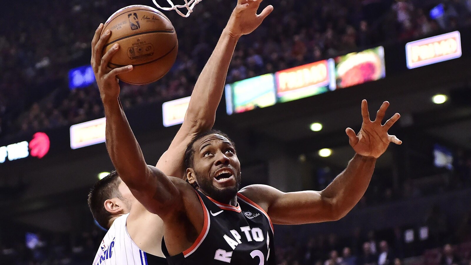 Leonard tente d'envoyer le ballon vers le panier en se défaisant de son adversaire du Magic, Nikola Vucevic.