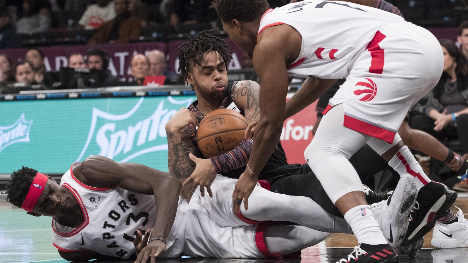 D'Angelo Russell des Nets tente de garder le ballon contre Pascal Siakam et Kyle Lowry des Raptors