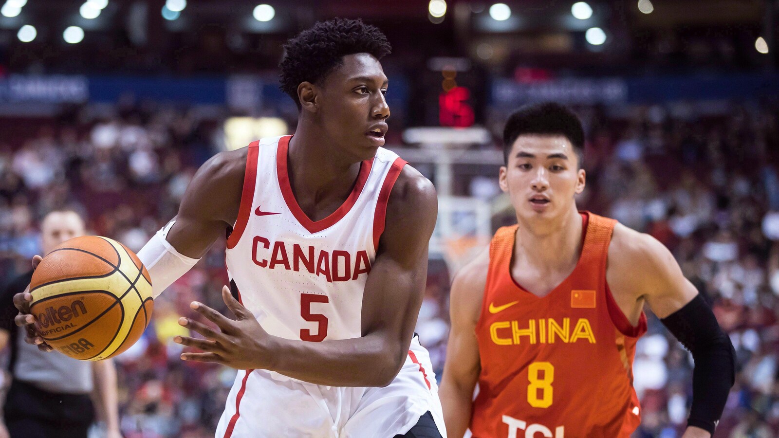 Le Canadien R.J. Barrett contrôle le ballon, surveillé par le Chinois Dehao Yu.