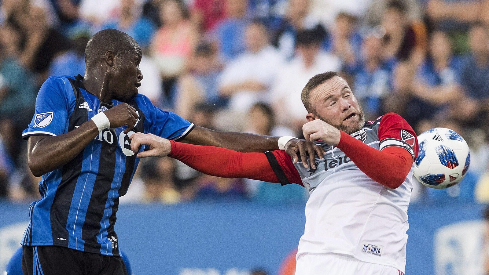Le défenseur de l'Impact Rod Fanni repousse l'attaquant du D.C. United Wayne Rooney.