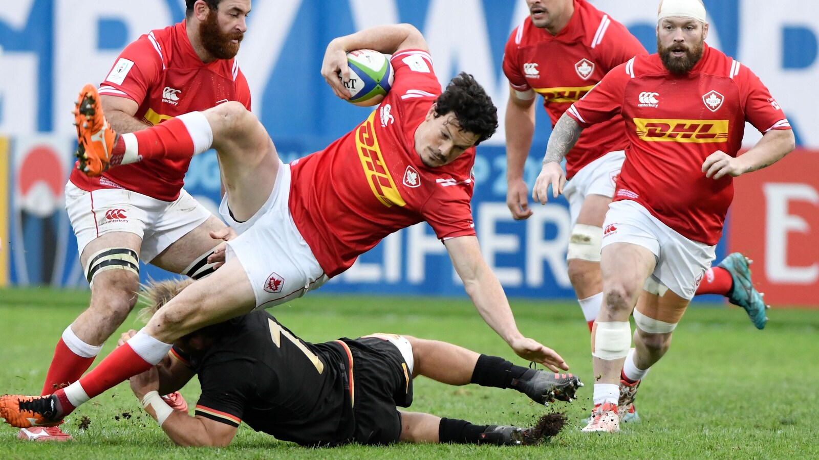 Le centre canadien Ciaran Hearn est plaqué par un joueur allemand pendant un match du tournoi de repêchage pour la Coupe du monde de rugby à XV.