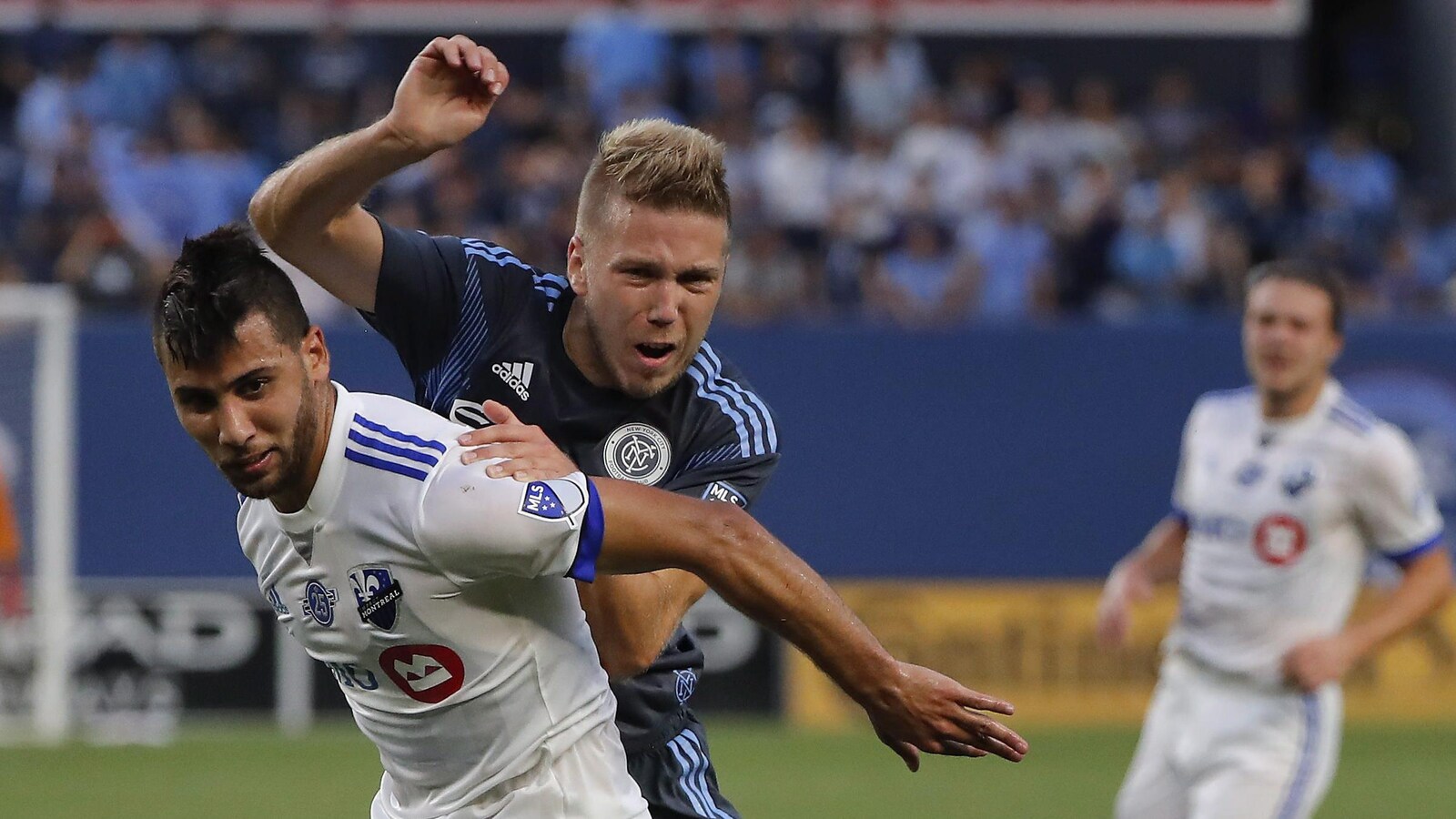 Saphir Taïder, de l'Impact de Montréal, lutte pour le ballon contre le défenseur Anton Tinnerholm, du New York City FC.