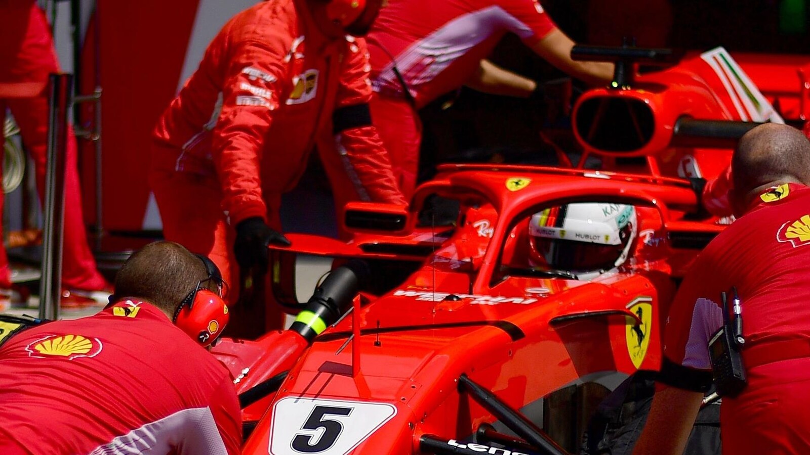 La voiture de Sebastian Vettel devant le garage Ferrari