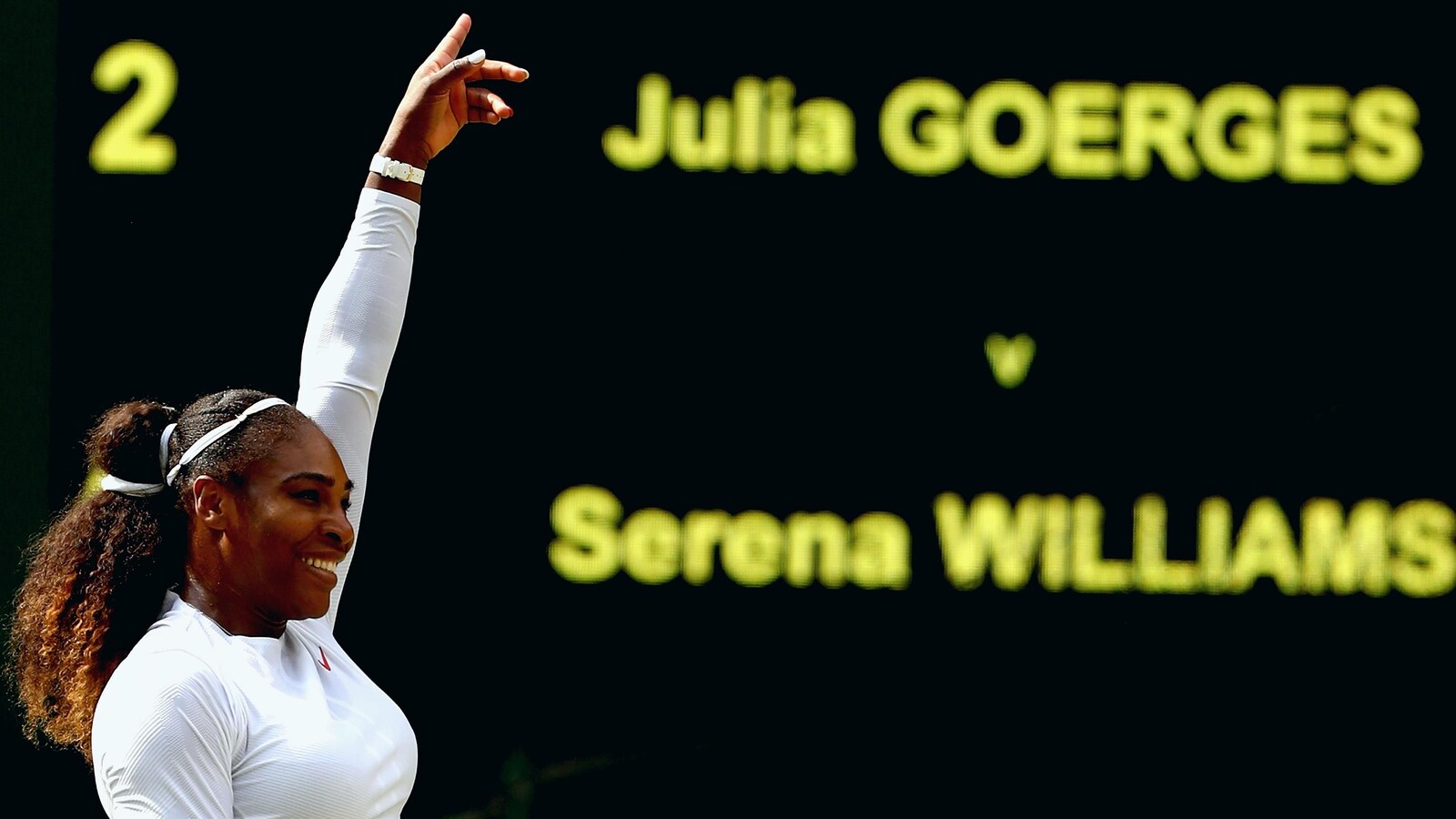 Serena Williams lève le bras gauche après sa victoire face à Julia Görges à Wimbledon.