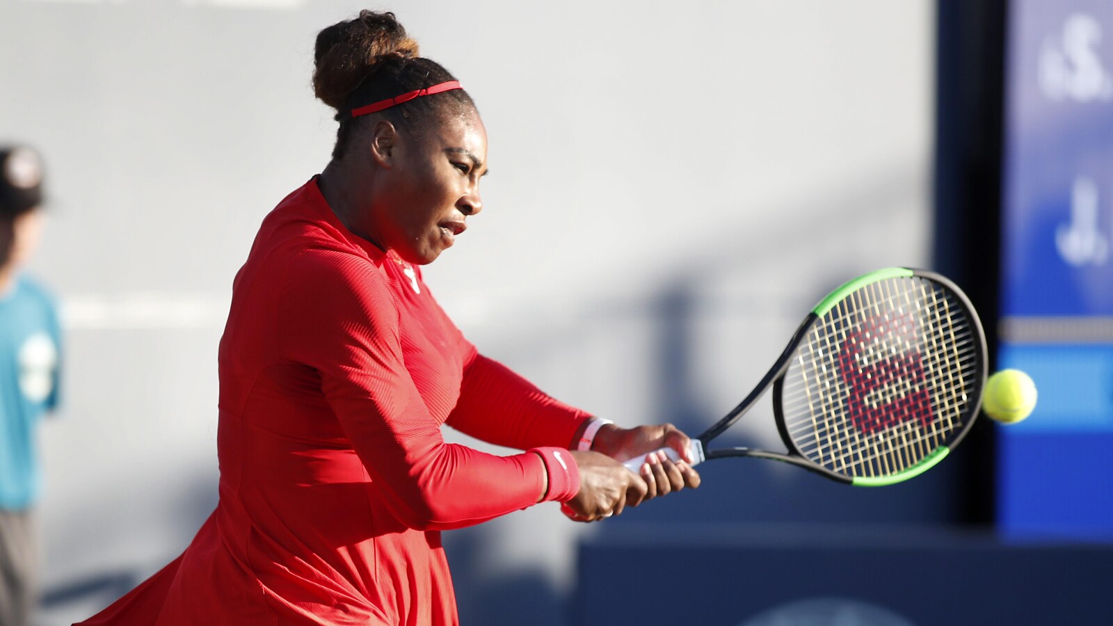 Serena Williams, en rouge, frappe une balle du revers.