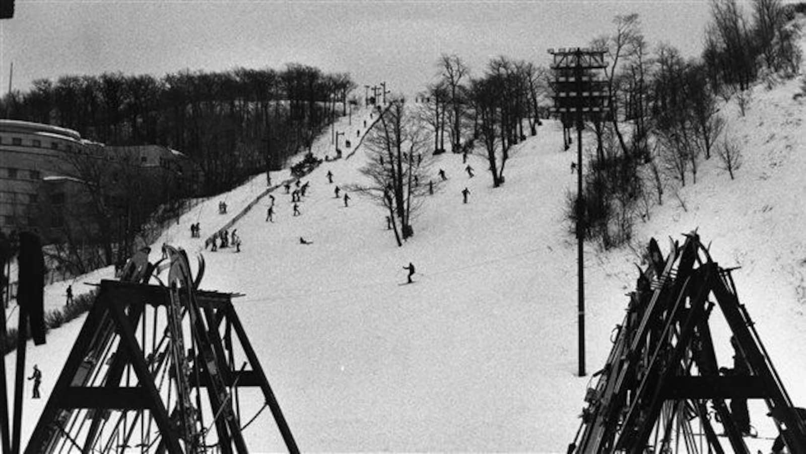 La photo en noir et blanc montre des skieurs à l'oeuvre.
