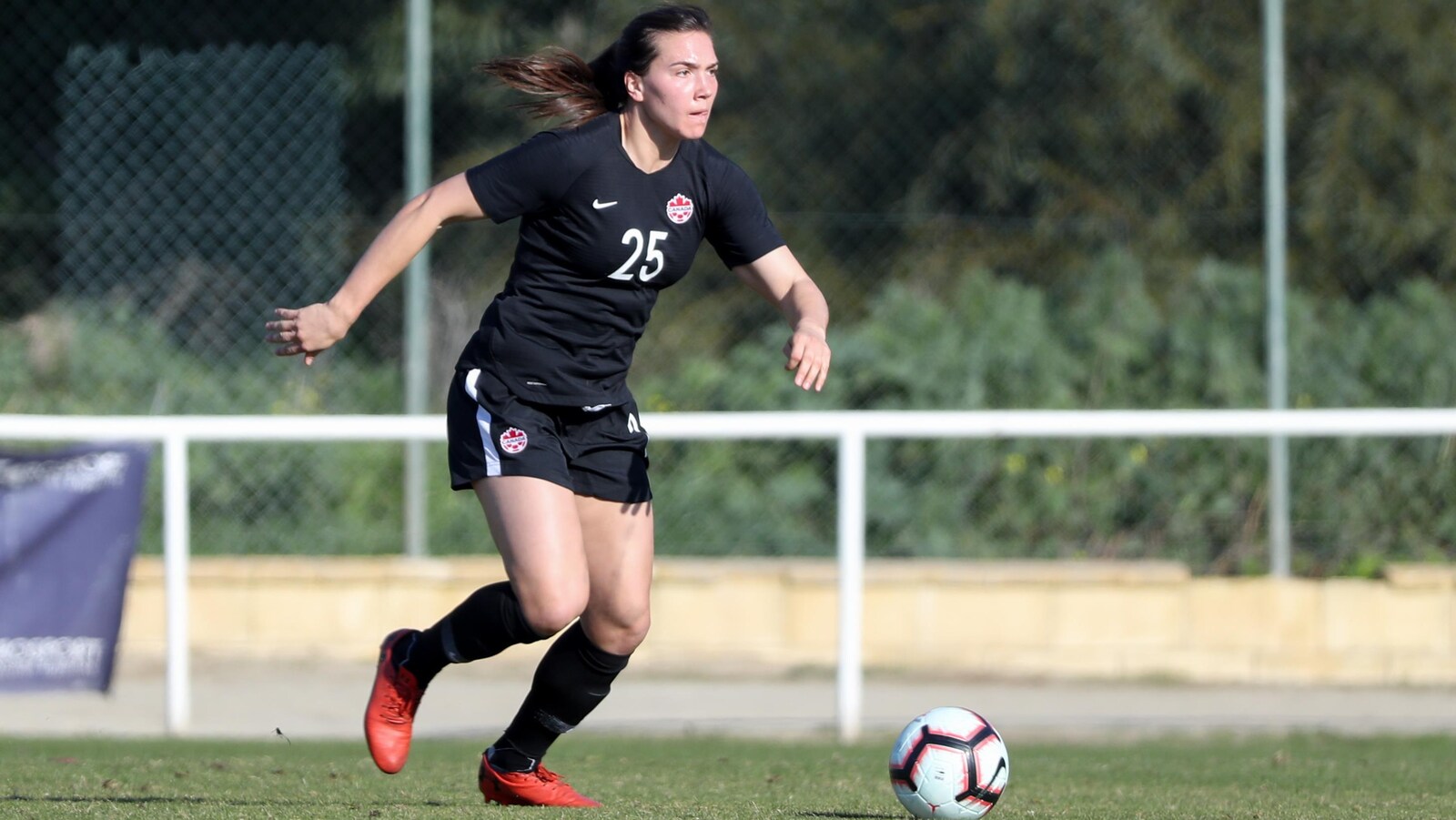 La joueuse de soccer Vanessa Gilles court, ballon au pied, sur un terrain gazonné