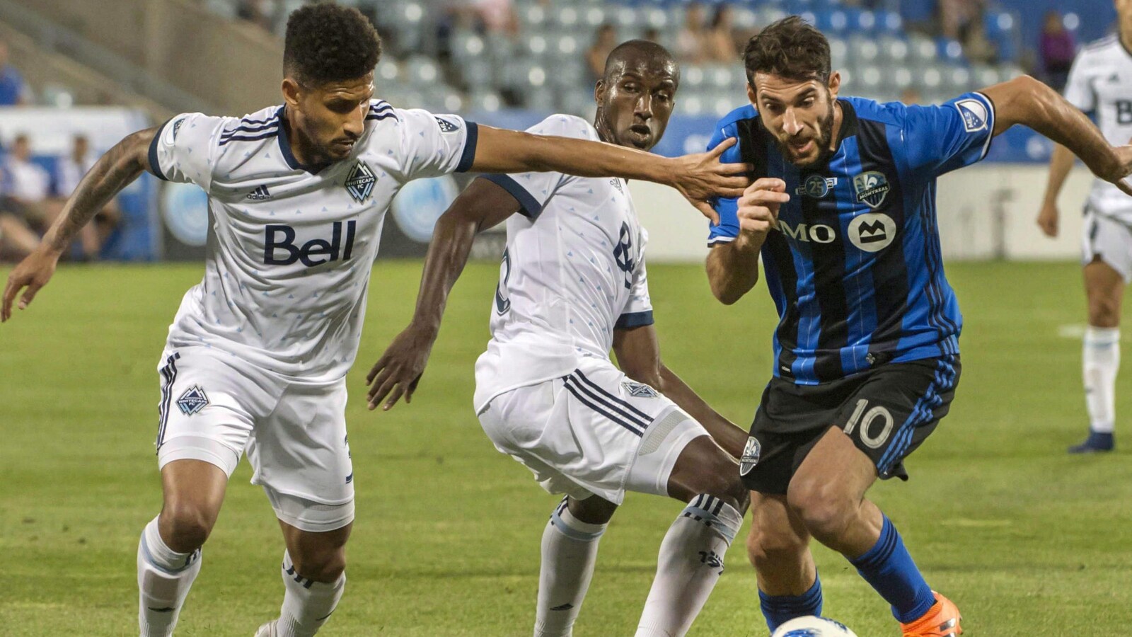 Ignacio Piatti de l'Impact de Montréal lutte pour le ballon avec Sean Franklin et Ali Ghazal des Whitecaps de Vancouver