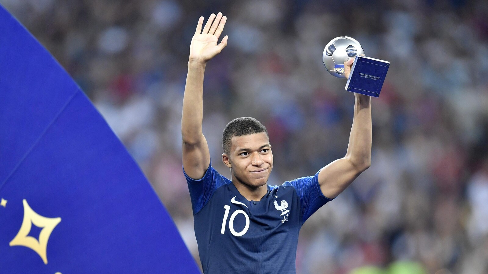 Le Français Kylian Mbappé soulève le trophée remis au meilleur jeune joueur de la Coupe du monde de 2018 après la victoire de son pays contre la Croatie en finale.