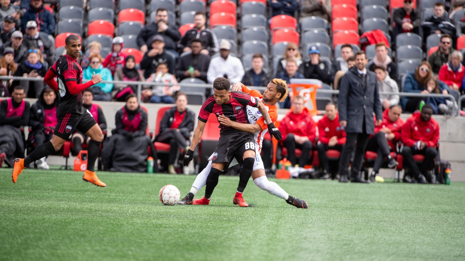 L'attaquant Kevin Oliveira protège le ballon devant le banc du Fury et son coéquipier Tony Taylor.