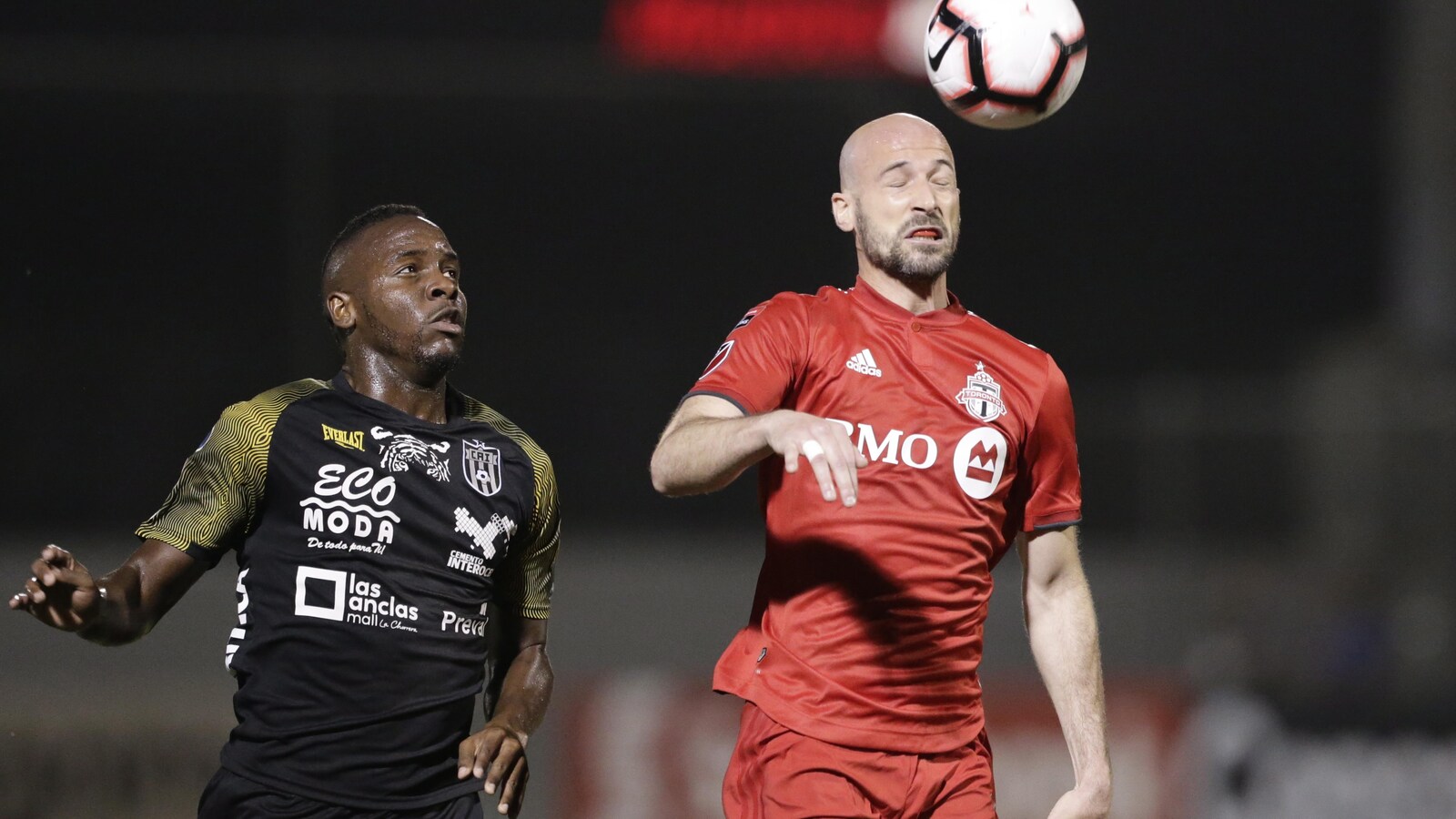 Laurent Ciman (à droite), du Toronto FC, reprend un ballon de la tête devant Ruben Barrow, du Club Atletico Independiente.