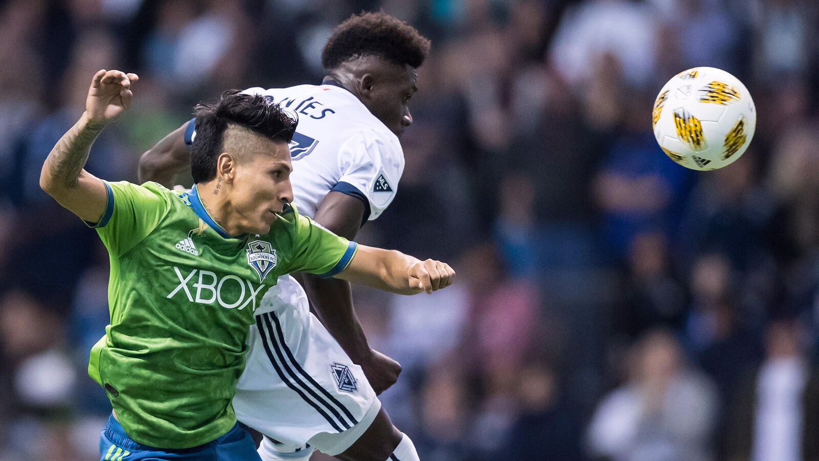 Raul Ruidiaz (à gauche), des Sounders des Seattle, dispute le ballon à Alphonso Davies, des Whitecaps de Vancouver.