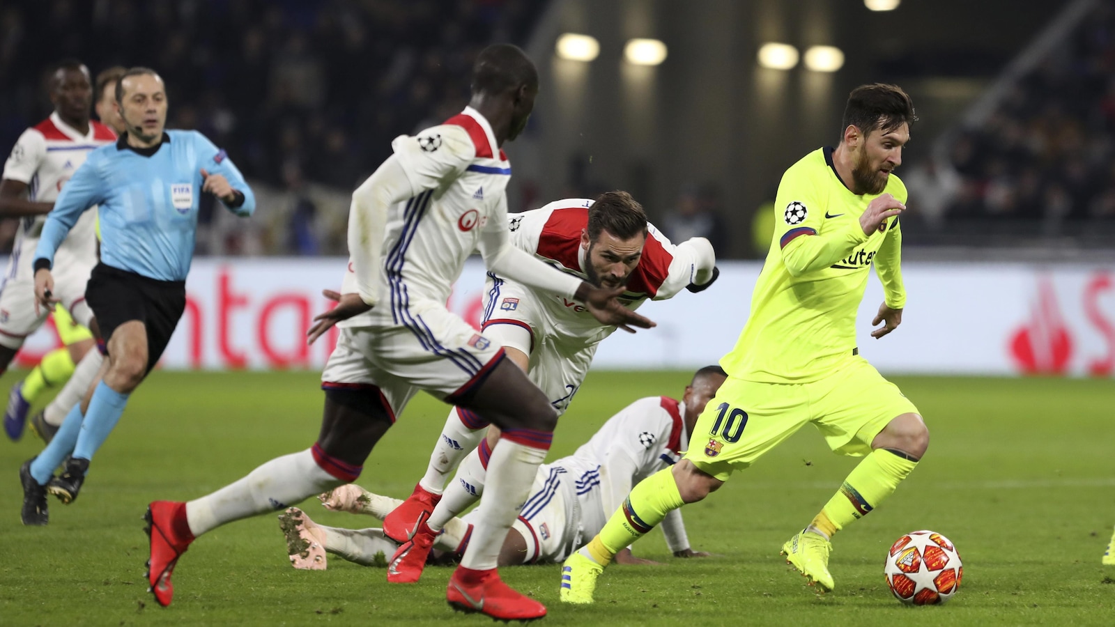 Lionel Messi (à droite), du FC Barcelone, tente de se sortir d'un amas de joueurs de l'Olympique Lyonnais avec le ballon.