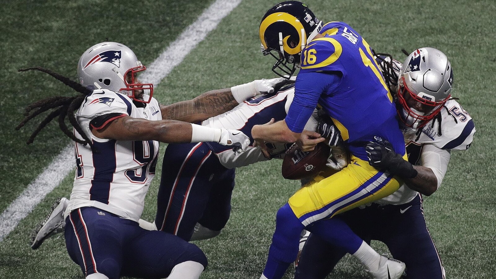 Trois joueurs des Patriots arrêtent le quart des Rams.