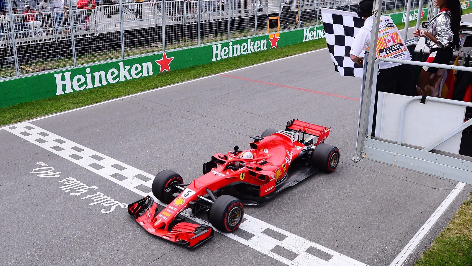 Le pilote Ferrari traverse la ligne d'arrivée sous le drapeau à damier pour remporter le Grand Prix