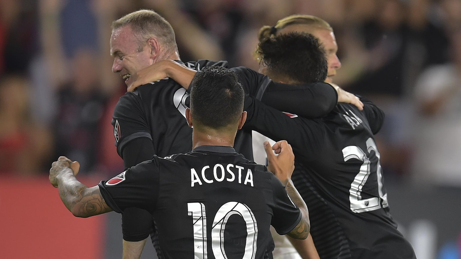Les quatre joueurs s'enlacent.