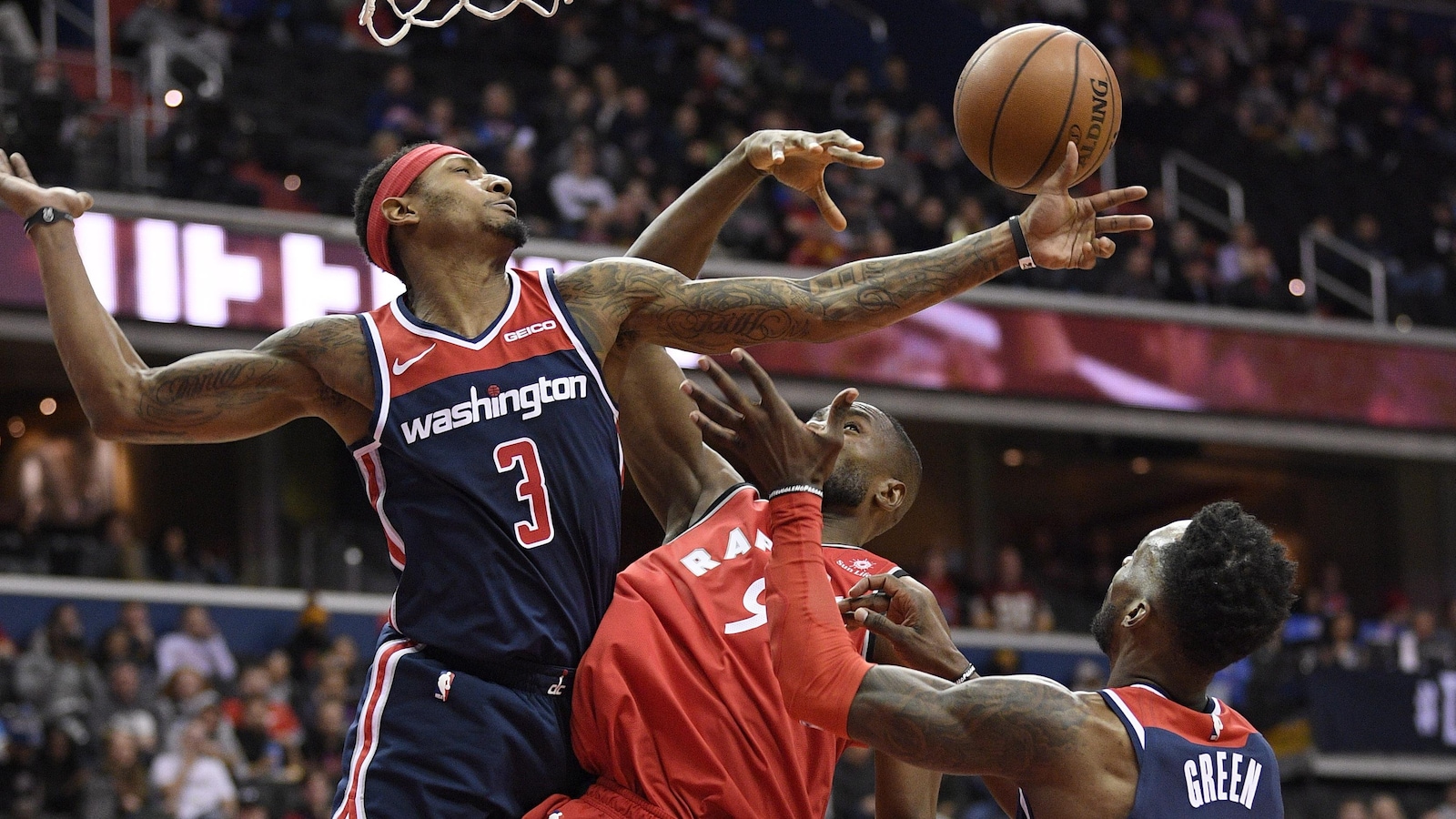 Bradley Beal et Jeff Green, des Wizards de Washington, luttent pour un rebond avec Serge Ibaka, des Raptors de Toronto.