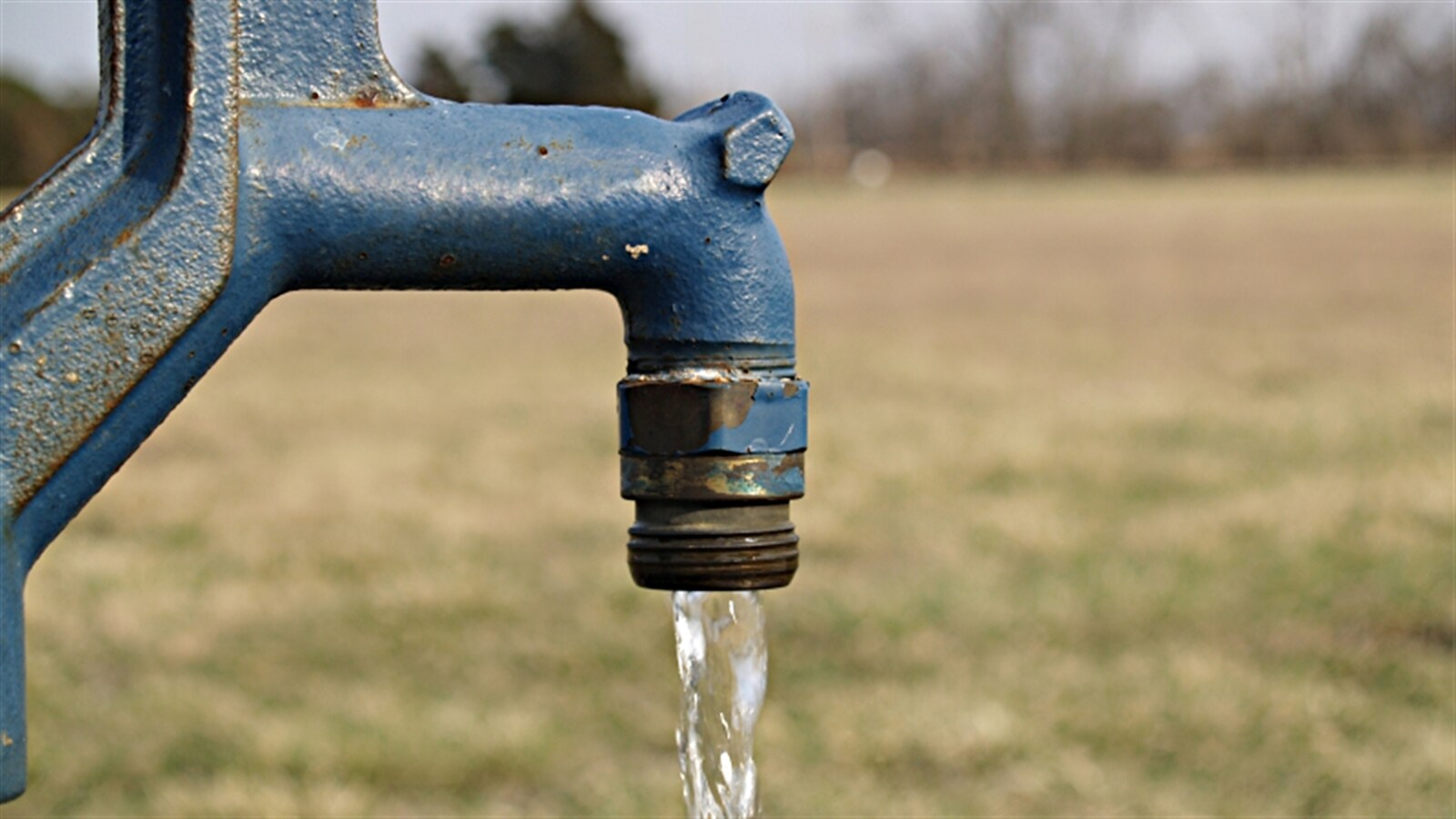 Un robinet extérieur d'où s'écoule de l'eau.